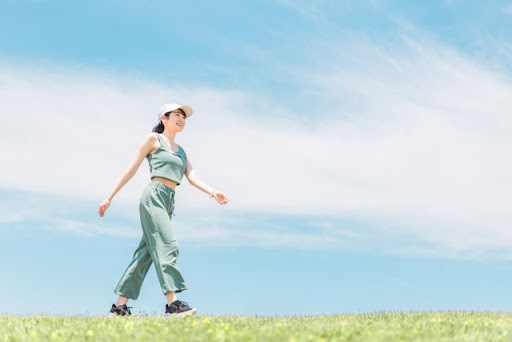 青空の下歩く女性