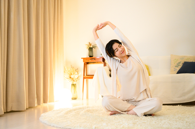 寝る前のストレッチ・ヨガをする女性